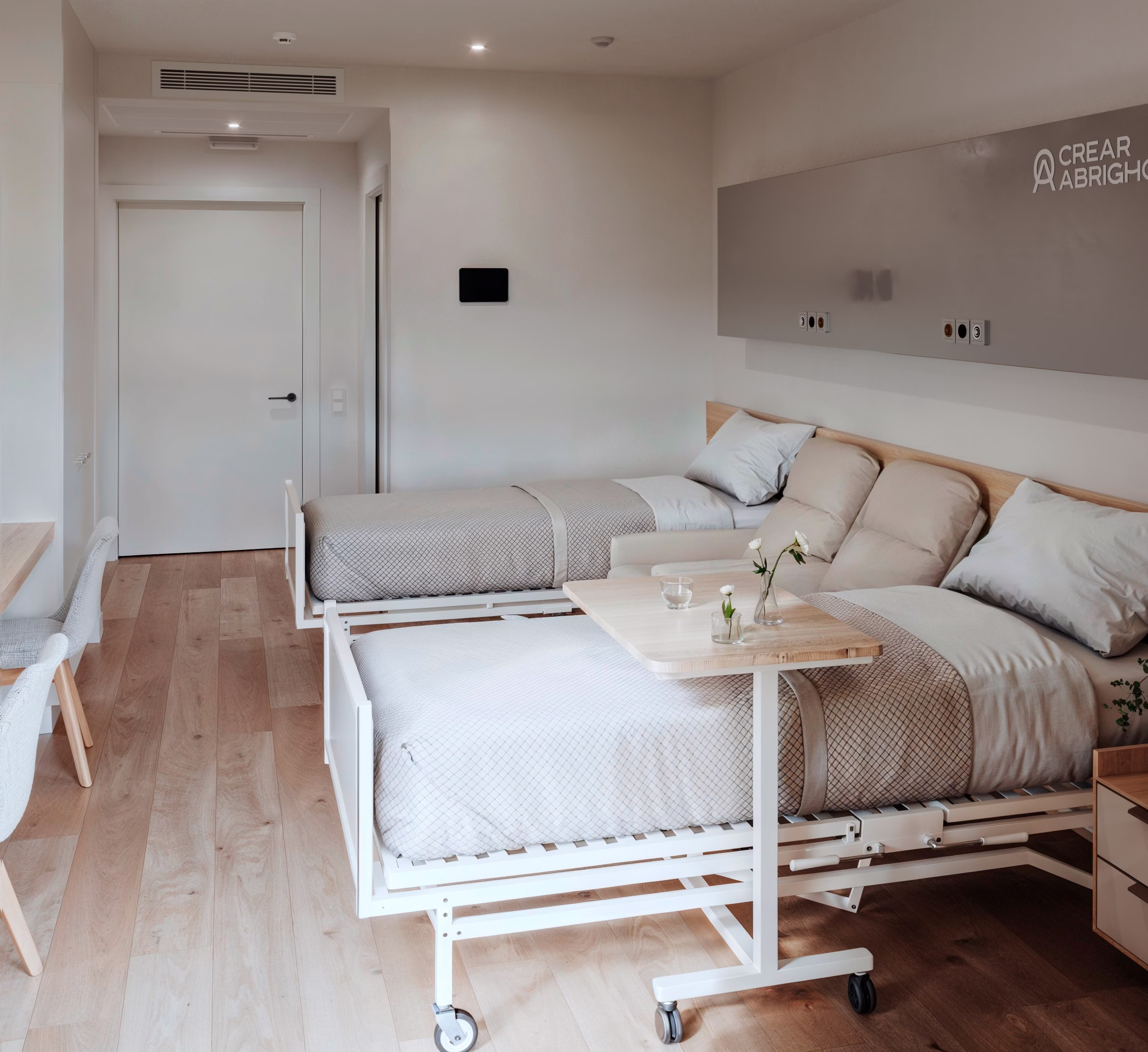 Camas de las unidades habitacionales de CREAR ABRIGHO Albacete, junto con un florero y una lámpara
